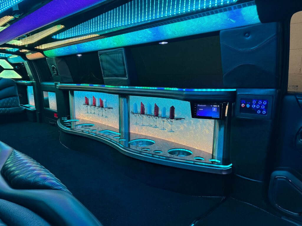 Cadillac Escalade Stretch Limo interior with custom leather seating, fiber-optic lighting, refreshment bar, and entertainment